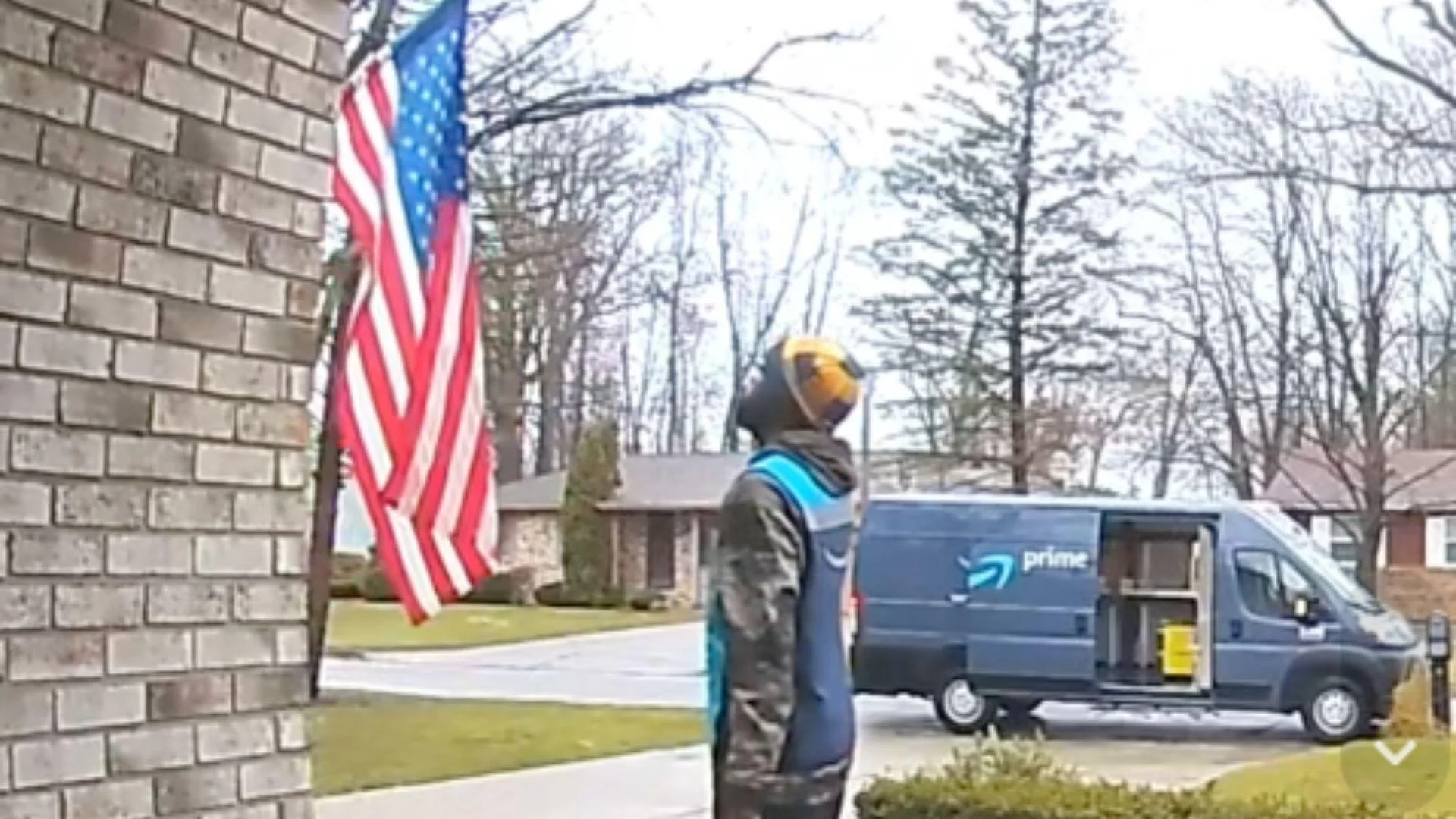 An Amazon delivery driver salutes a flag outside a customer’s home - X