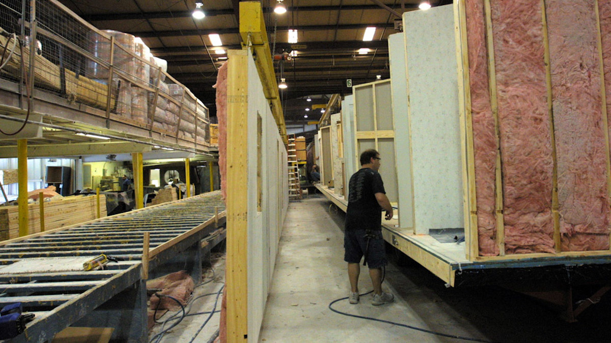 Manufactured homes' side walls are built and then lifted into place.